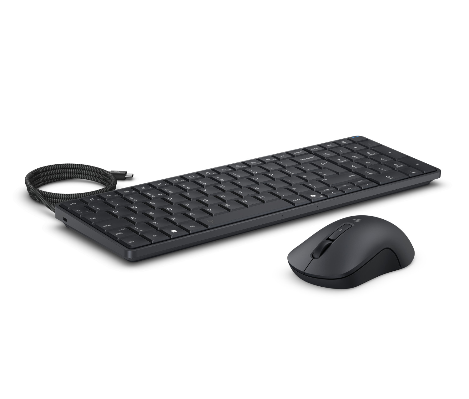 Un set di tastiera e mouse neri con cavo su superficie bianca, con cavo USB arrotolato.