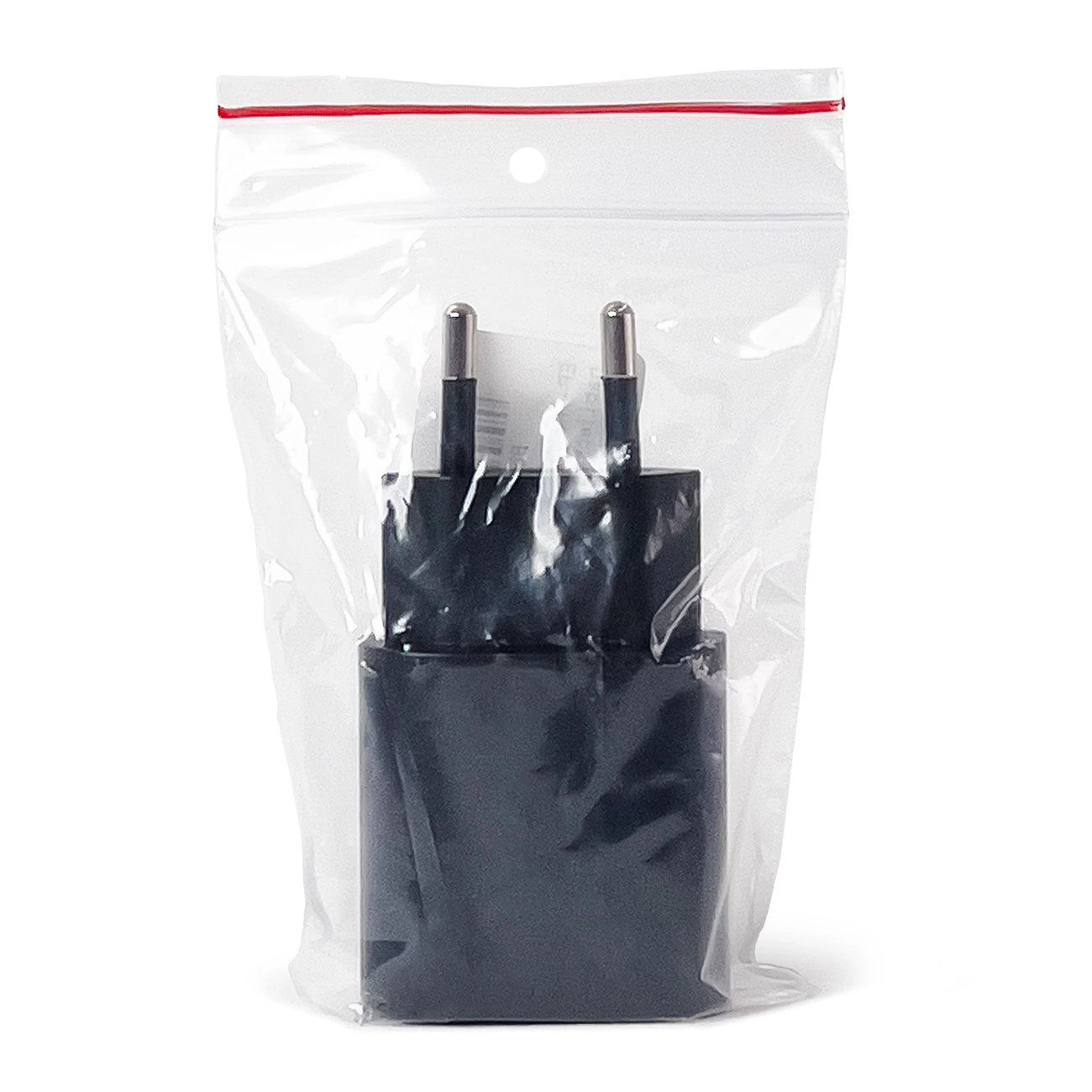 Un adattatore di alimentazione nero in una busta di plastica trasparente su sfondo bianco.