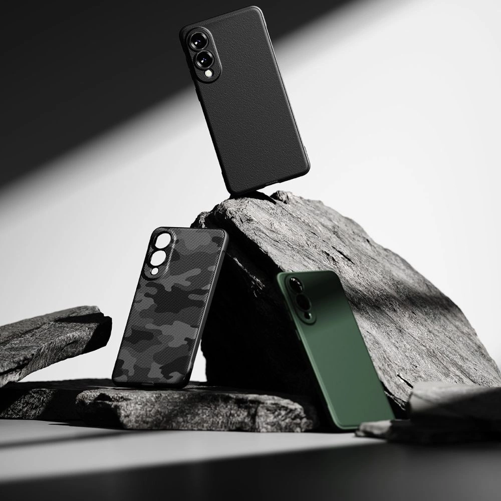 Drei Smartphones mit verschiedenen Hüllen in Schwarz, Tarnmuster und Grün stehen auf grauen Steinen.