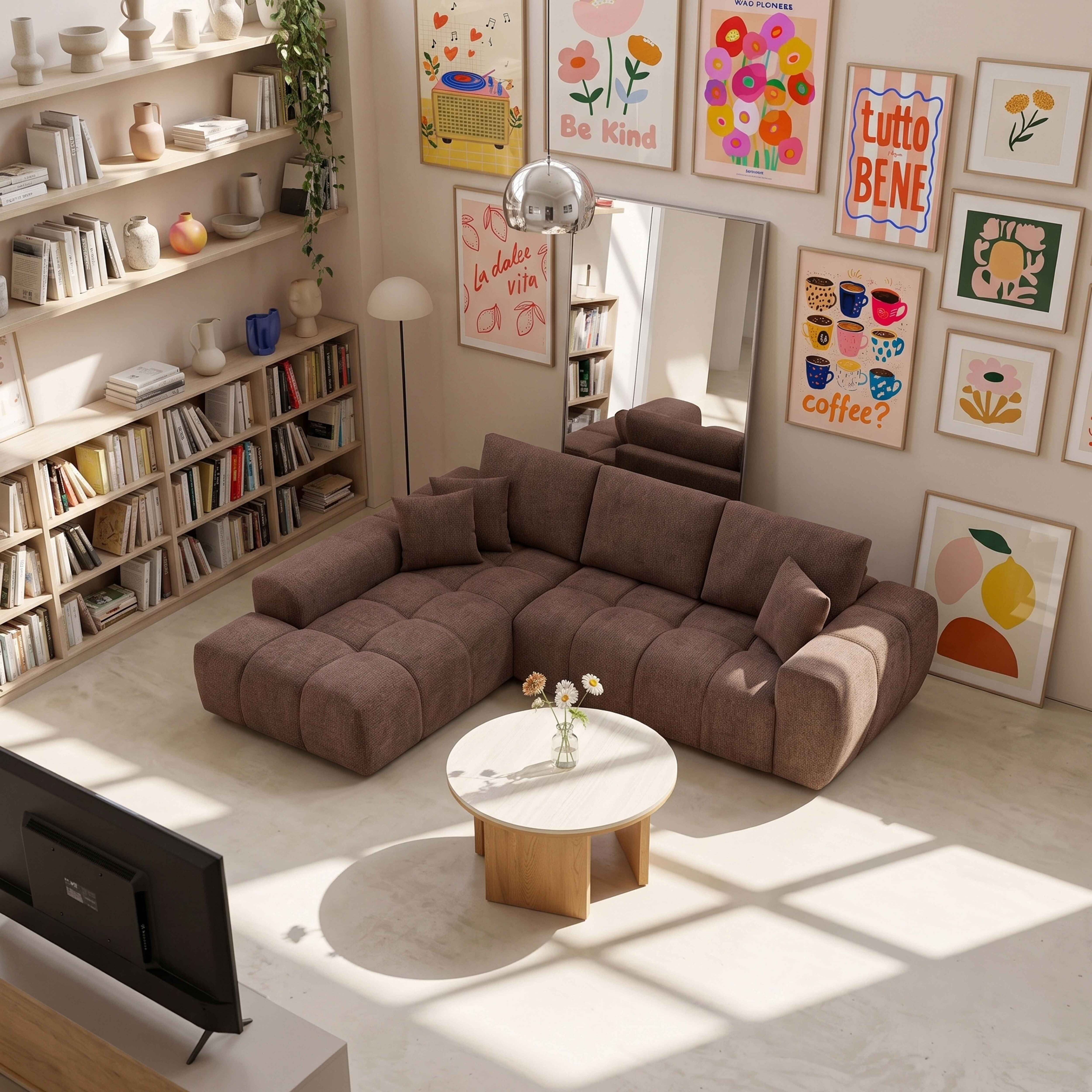 Ein gemütliches Wohnzimmer mit braunem Sofa, rundem Holztisch, großen Regalen und bunter Wandkunst.