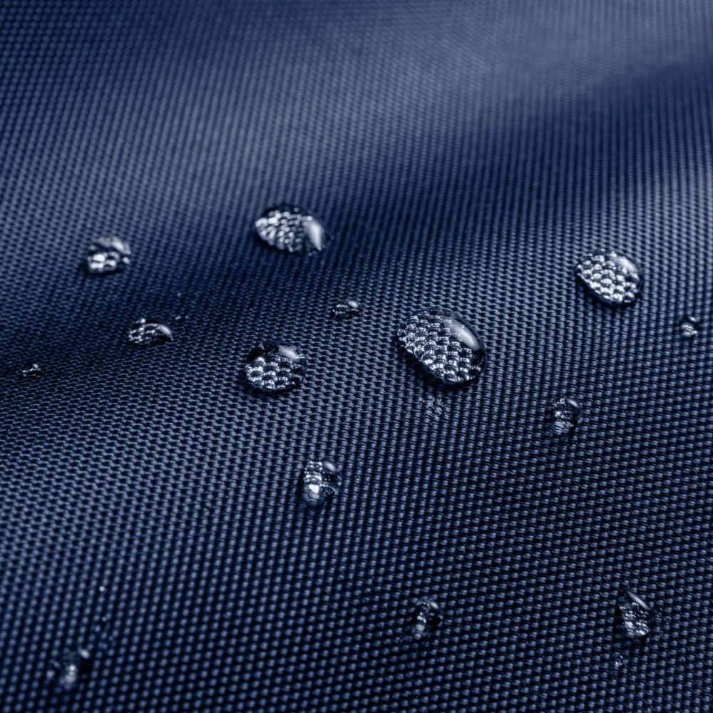 Wassertropfen auf einer dunkelblauen, wasserabweisenden Gewebeoberfläche.