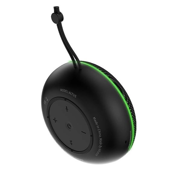 Enceinte Bluetooth ronde noire avec un anneau lumineux vert et une dragonne sur fond blanc.