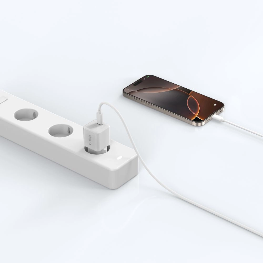 Un smartphone est branché sur une multiprise blanche à l'aide d'un chargeur et d'un câble.