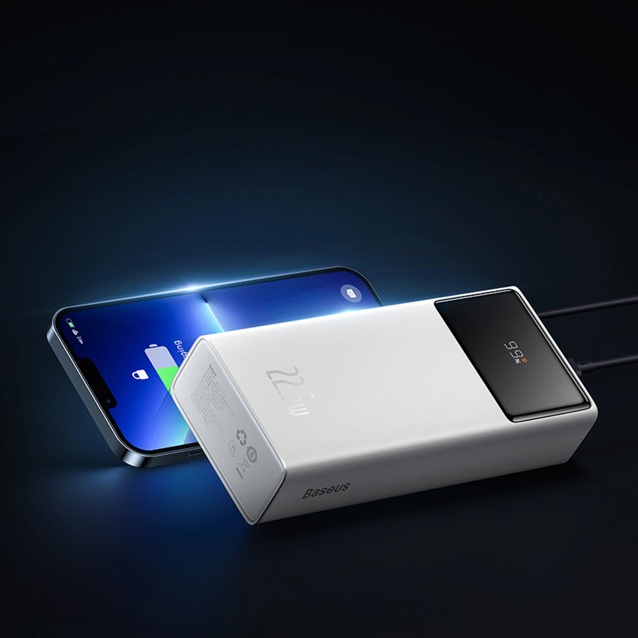 Un power bank Baseus bianco e uno smartphone con schermo blu su sfondo scuro.