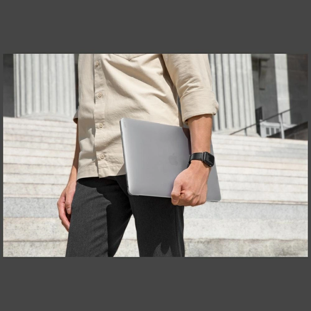 Persona con camicia beige tiene laptop su gradini di pietra con colonne.