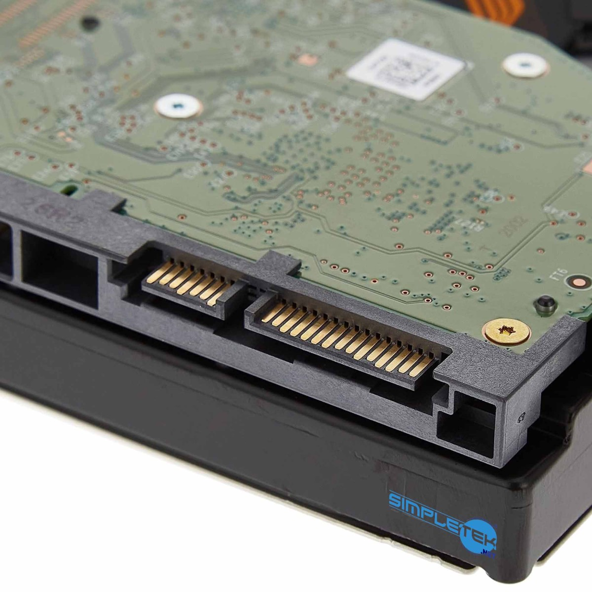 Primo piano di un disco rigido che mostra il circuito verde e i pin del connettore SATA dorati.