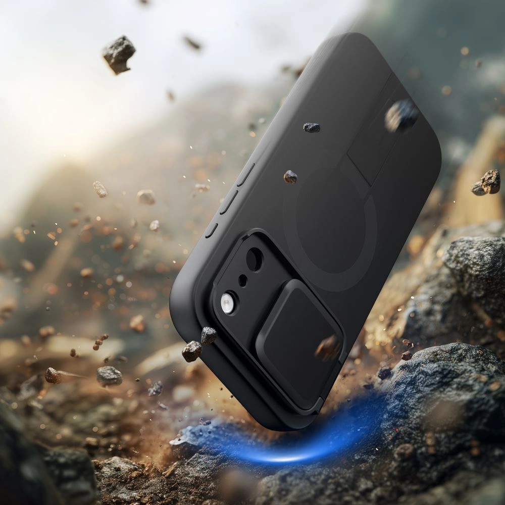 Ein schwarzes Smartphone fällt auf steinigen Boden, umgeben von aufgewirbelten Steinen und Staub.