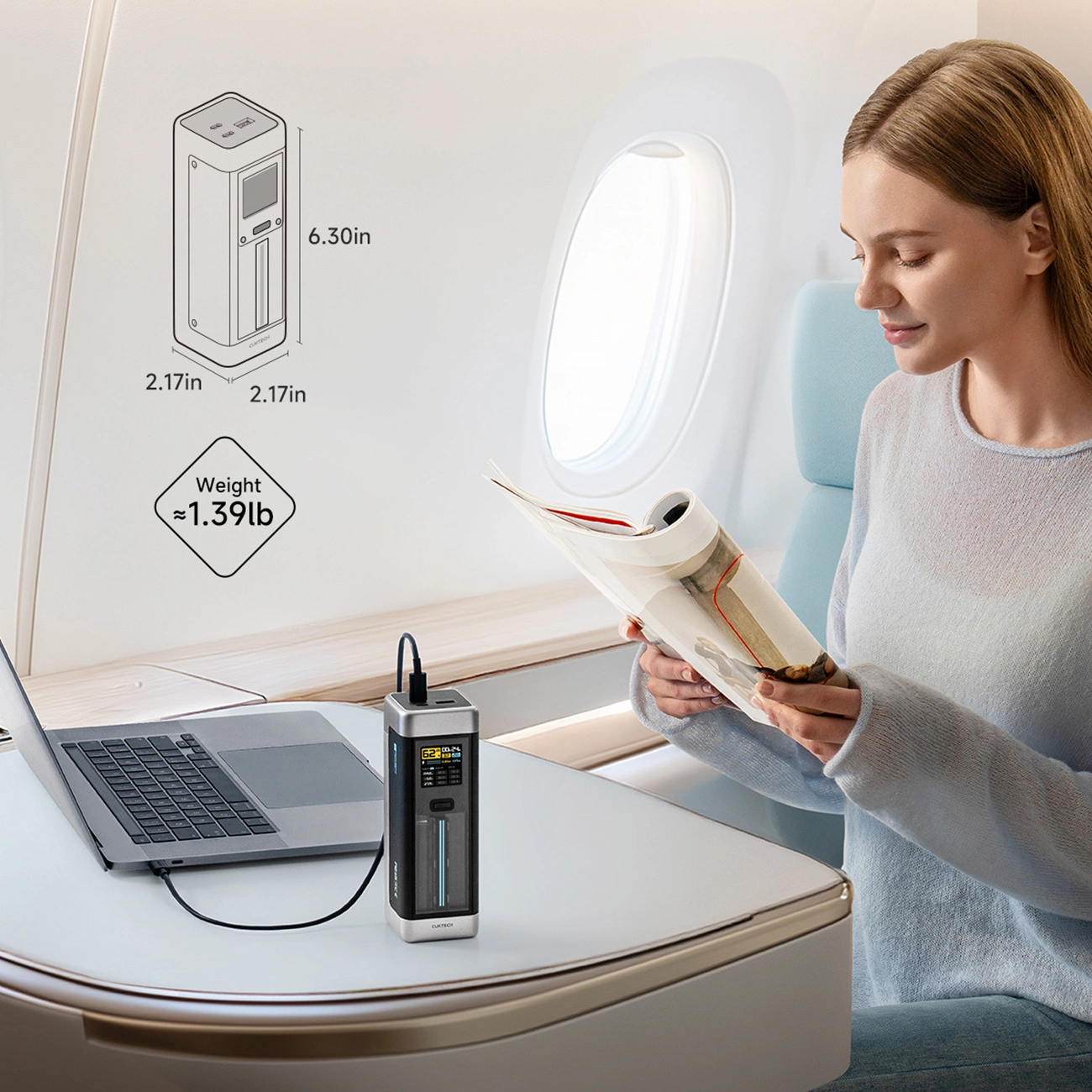 Una donna legge in aereo mentre un power bank ricarica un computer.