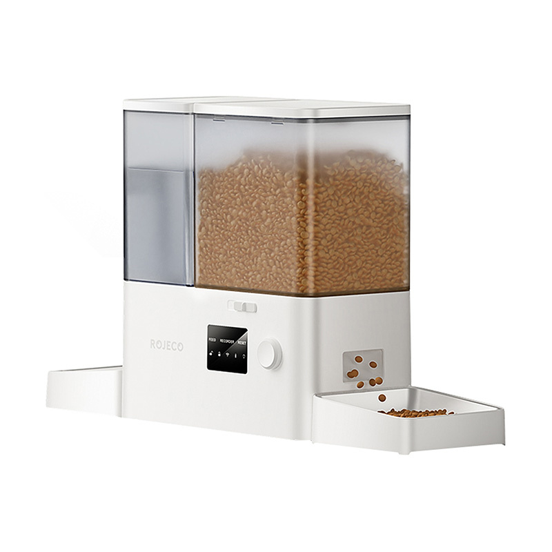 Distributore automatico di cibo bianco pieno di crocchette, con display digitale, pulsanti e doppia ciotola su sfondo bianco.