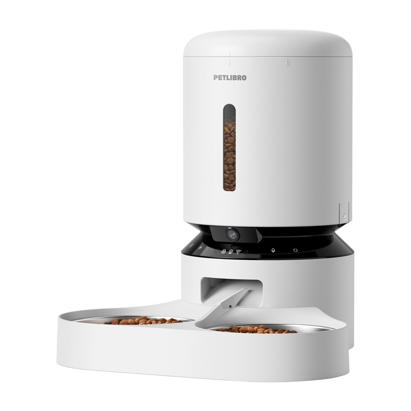 Distributore automatico bianco Petlibro con fotocamera e due ciotole piene di crocchette.