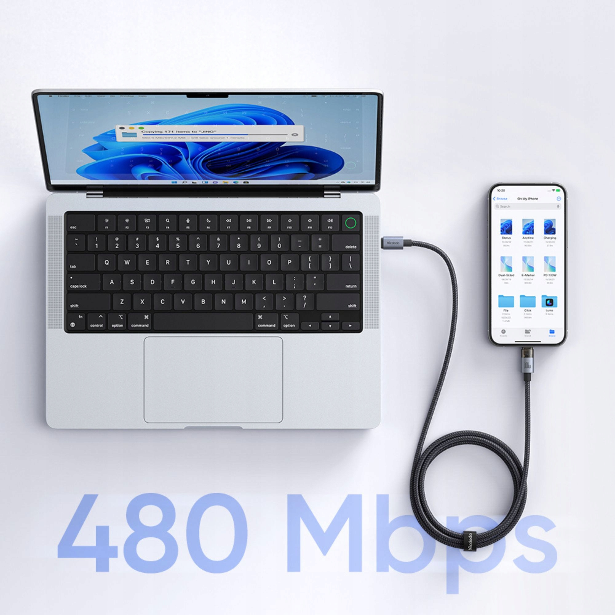 Gümüş renkli bir dizüstü bilgisayar, siyah bir kabloyla akıllı telefona bağlı. Önde 480 Mbps yazısı var.