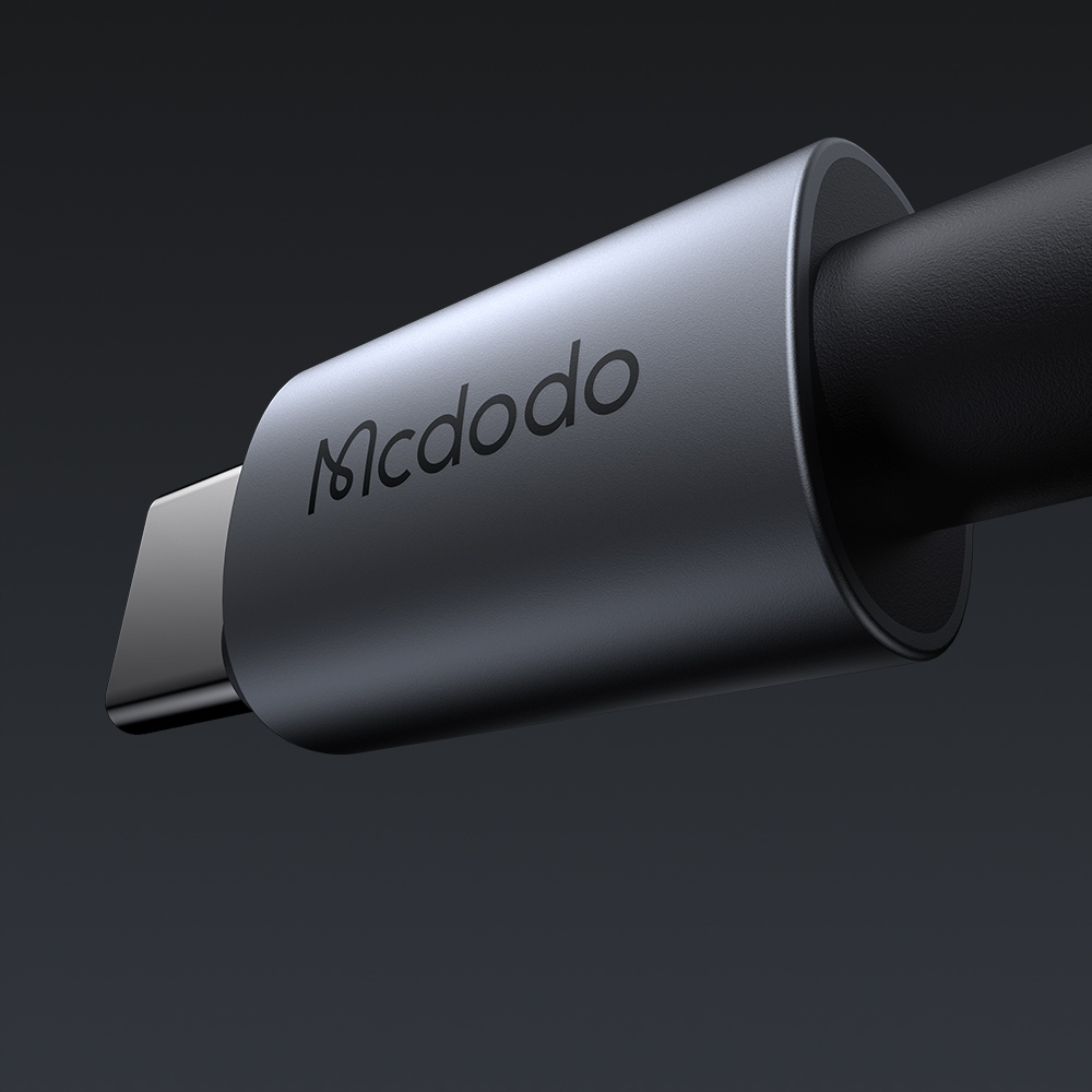 Koyu arka planda koyu gri bir Mcdodo USB-C kablo konektörünün yakın çekimi.