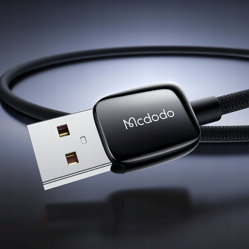 Koyu arka plan üzerinde örgülü kabloya sahip siyah bir Mcdodo USB kablo konektörü.