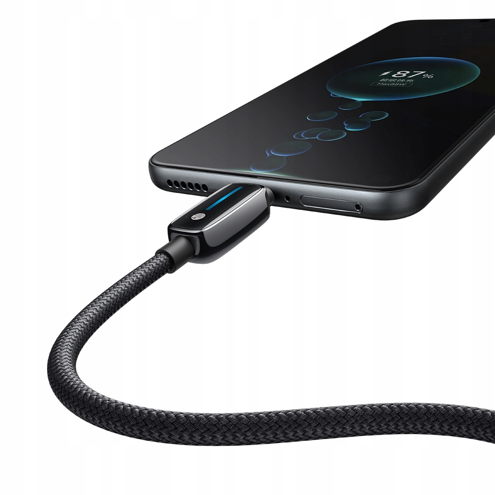 Siyah bir akıllı telefon örgülü bir USB kablosuyla şarj ediliyor; ekranda bir şarj animasyonu görünüyor.