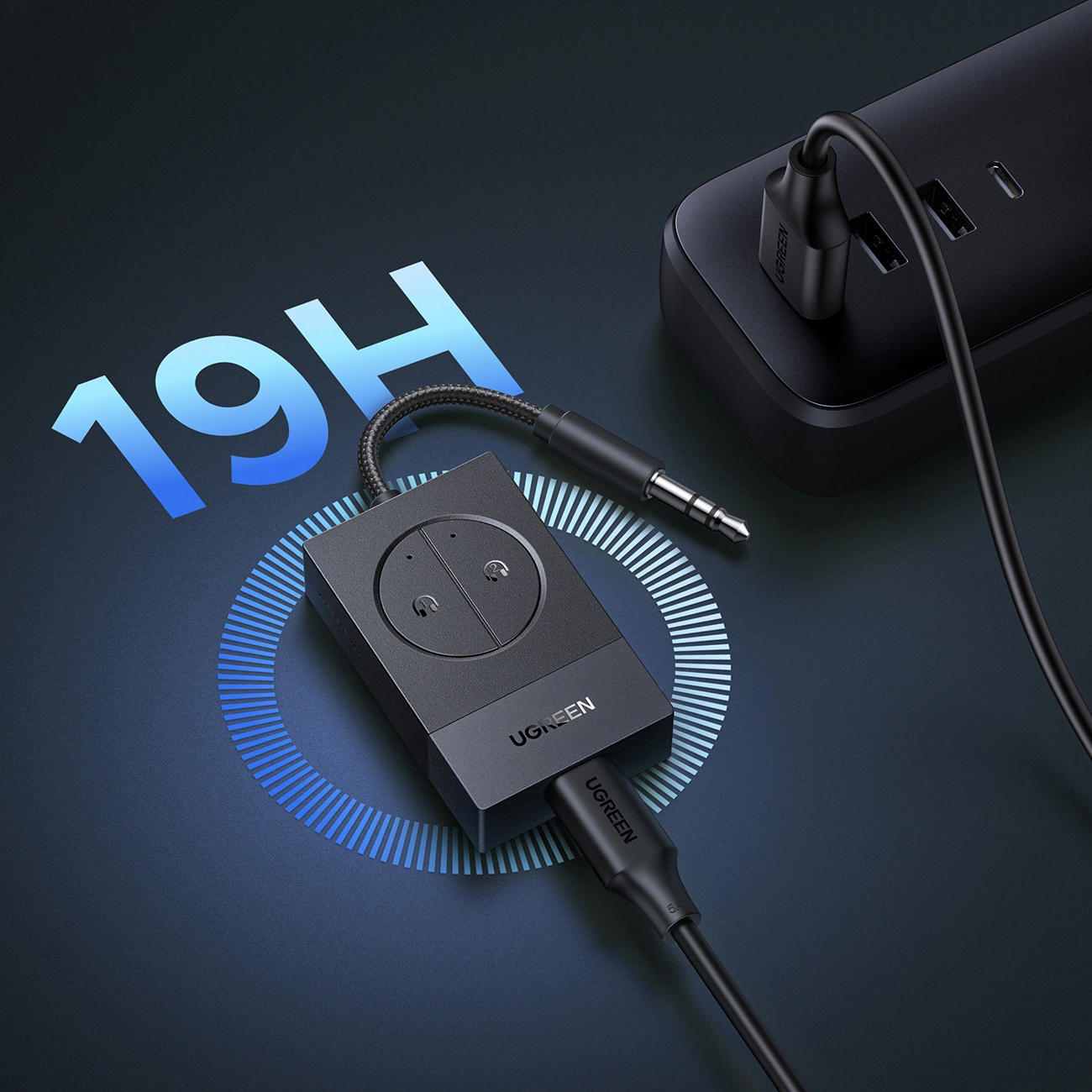 Un adattatore Bluetooth UGREEN nero con jack si trova su una superficie scura accanto a un caricabatterie.