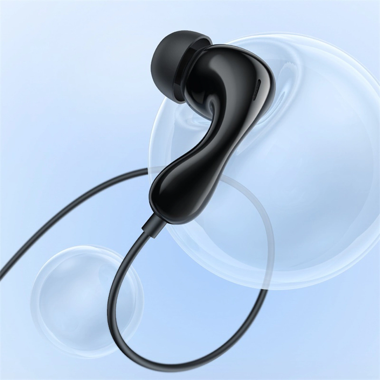 Auricolare nero lucido con cavo su sfondo azzurro con sfere trasparenti.