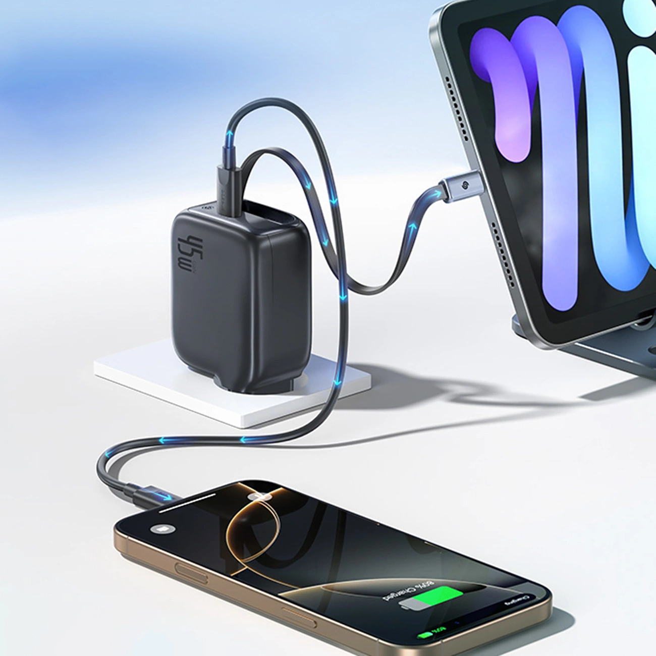 Un caricatore nero da 45W carica contemporaneamente uno smartphone e un tablet con indicatori di carica blu su base bianca.