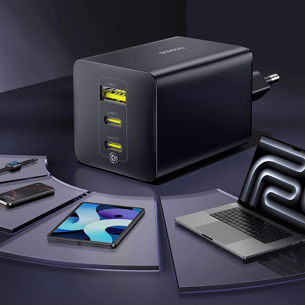 Un caricabatterie multiporta nero su superficie scura, circondato da dispositivi come laptop, tablet, telefono e orologio.
