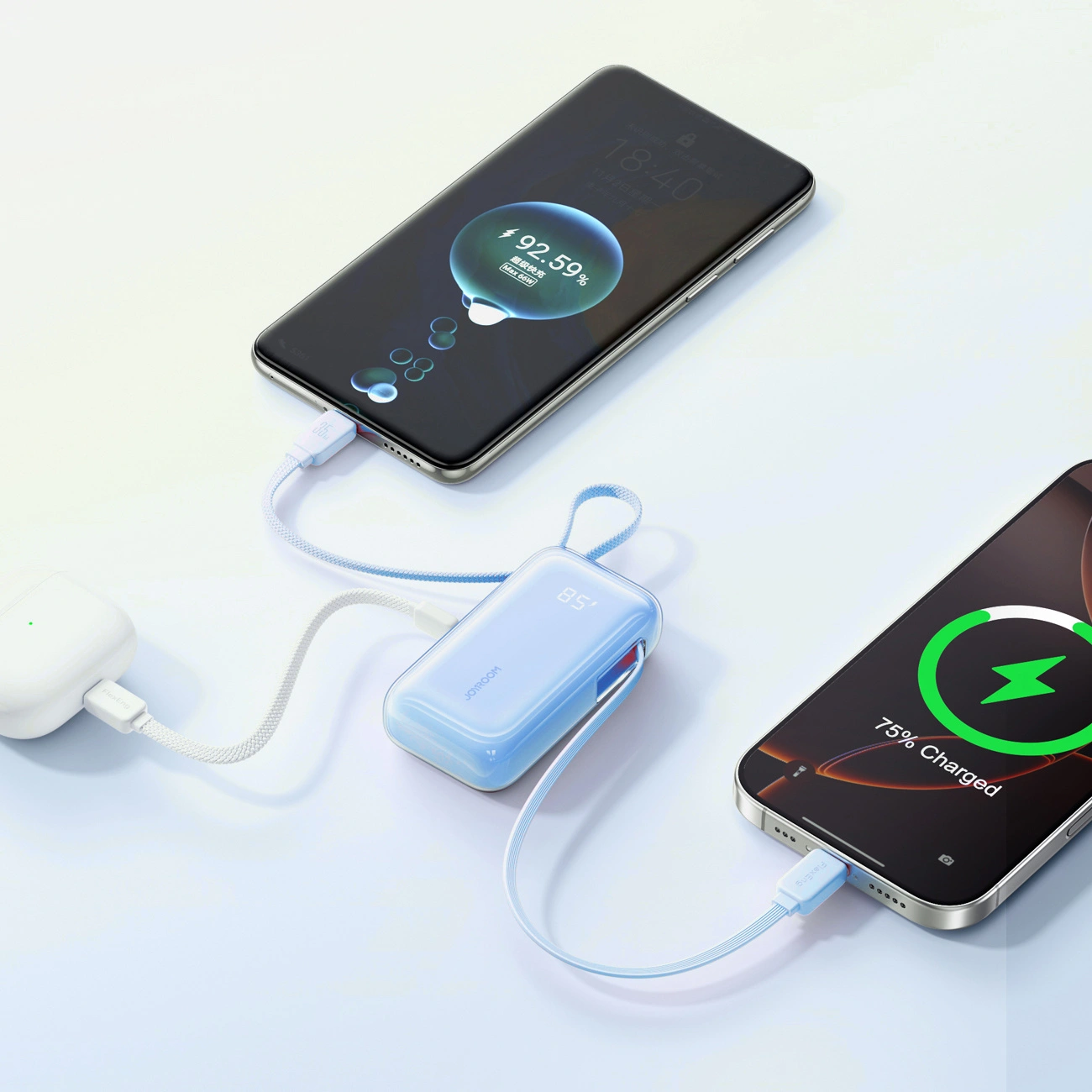 Une batterie externe bleue recharge deux smartphones et un étui blanc avec des câbles tressés.