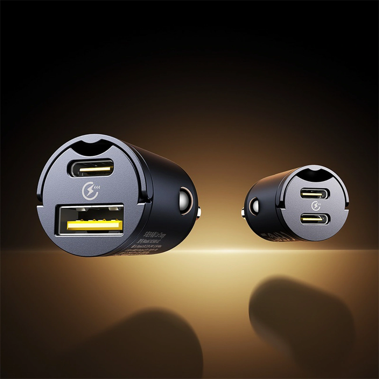 Due caricabatterie per auto neri con porte USB-A e USB-C su sfondo marrone scuro lucido.