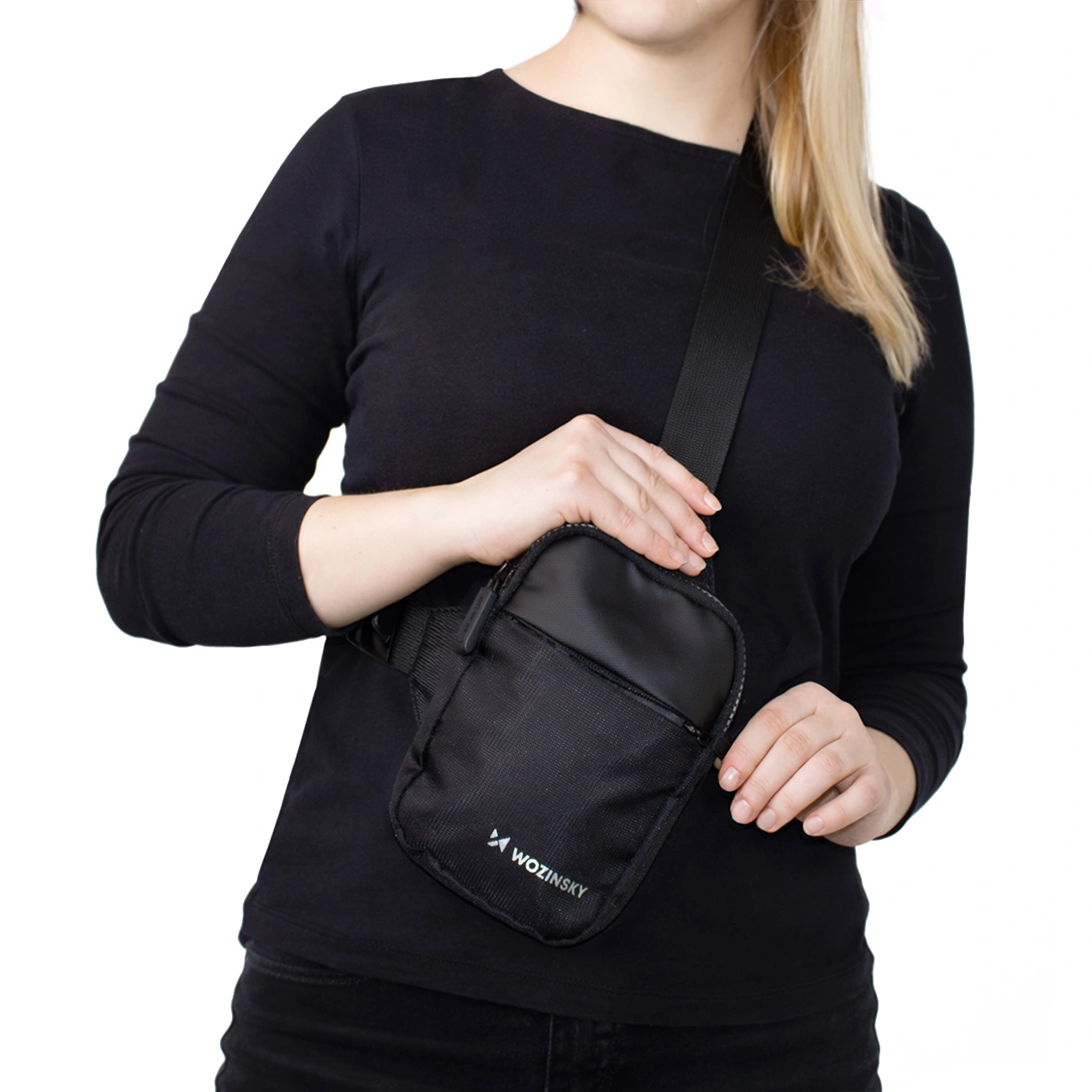 Una donna con un top nero indossa una piccola borsa a tracolla nera con il logo Wozinsky bianco.