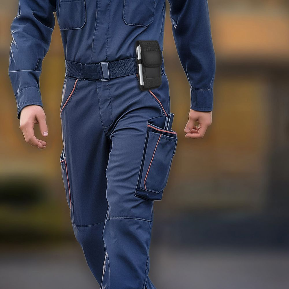 Ein Arbeiter in blauer Arbeitskleidung mit Gürtel und einer Handytasche an der Seite.