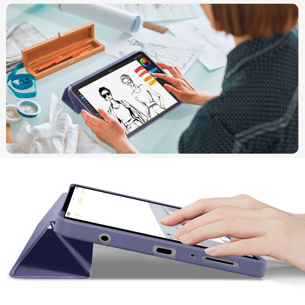 Persona che disegna bozze di moda su un tablet viola in uno studio luminoso.