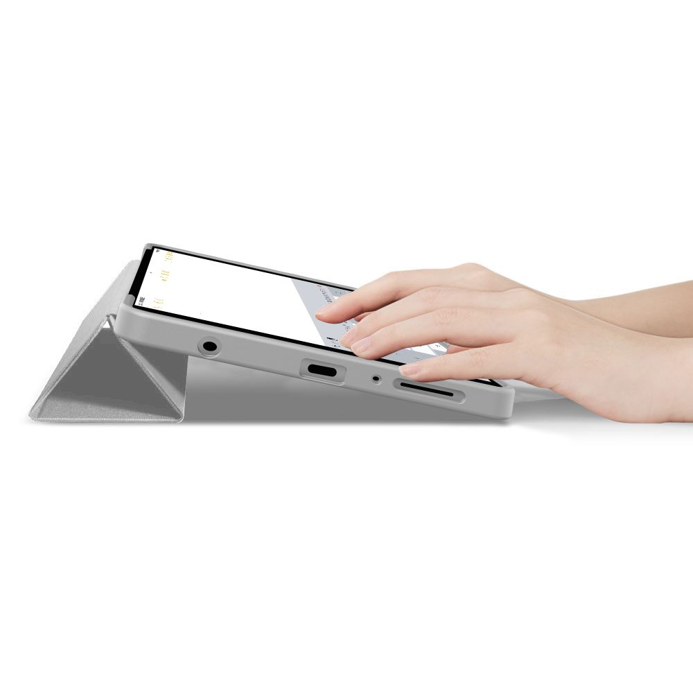 Mani che digitano sulla tastiera di un tablet appoggiato su una custodia grigia con sfondo bianco.
