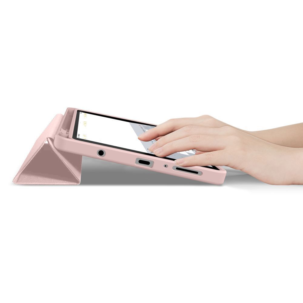 Una persona digita su un tablet rosa in un supporto pieghevole triangolare su sfondo bianco.