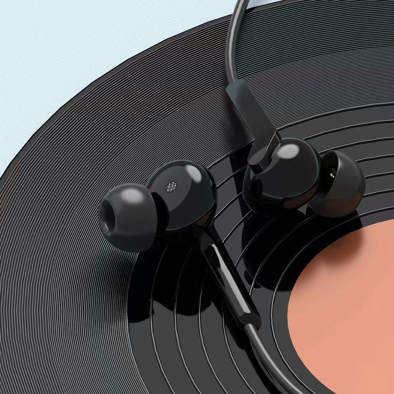 Schwarze In-Ear-Kopfhörer mit Kabel liegen auf einer analogen Schallplatte mit orangem Label.