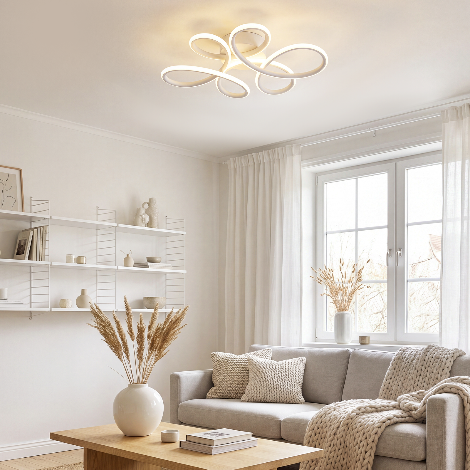 Salón luminoso con moderna lámpara de techo blanca, sofá gris, mesa de centro de madera y estantes blancos.
