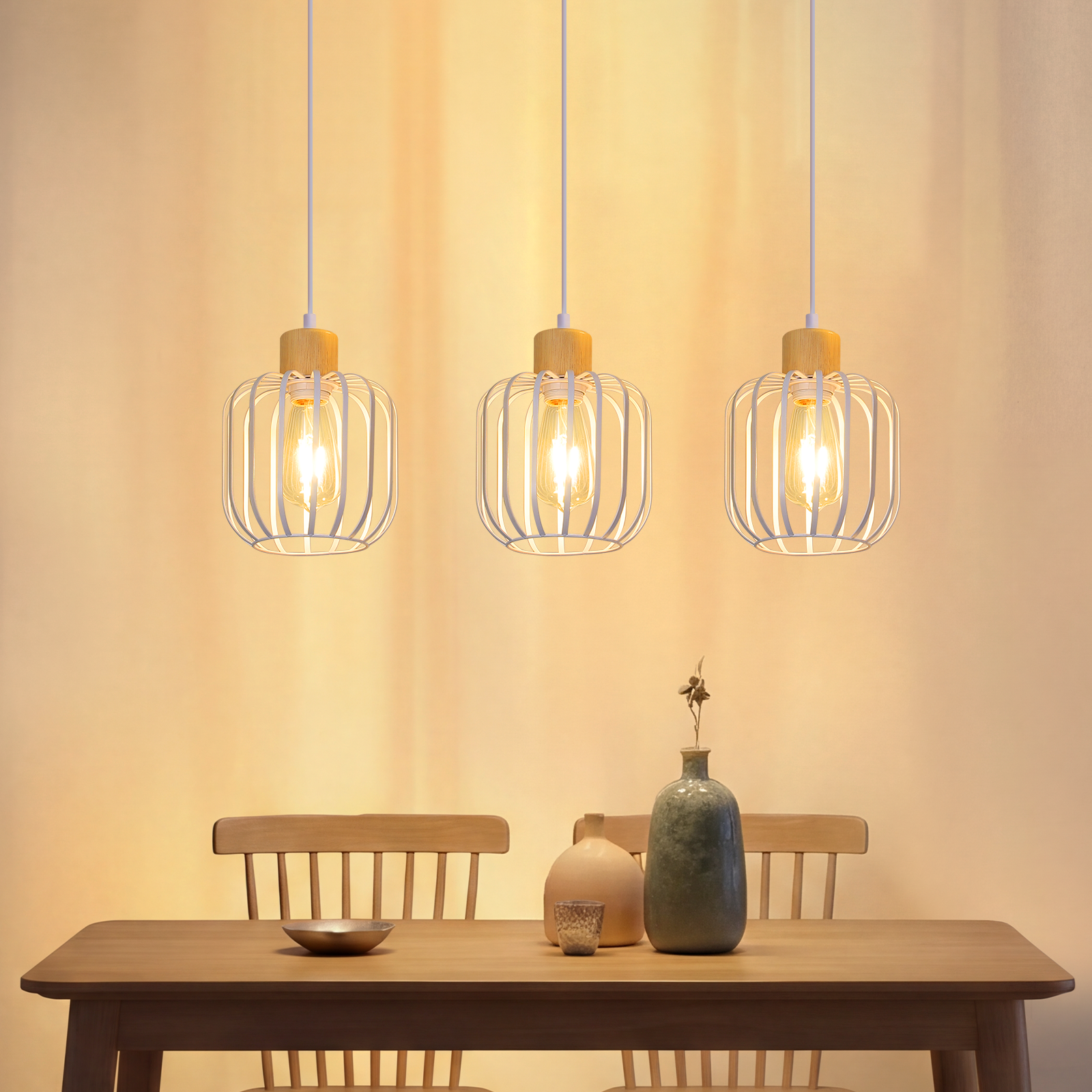 Tres lámparas colgantes sobre una mesa de madera con sillas y floreros.