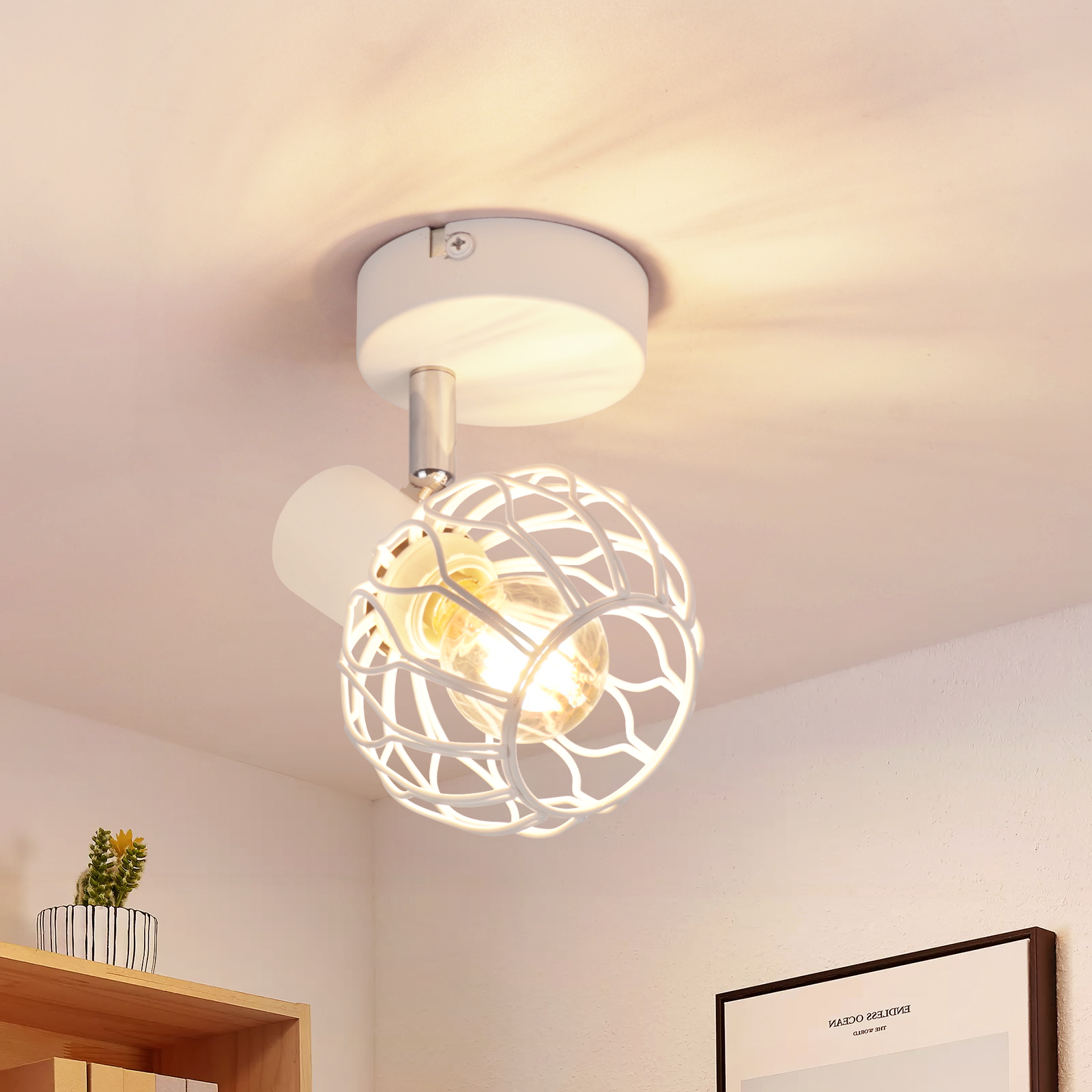 Un foco de techo de metal blanco está montado en el techo, brillando con luz cálida.