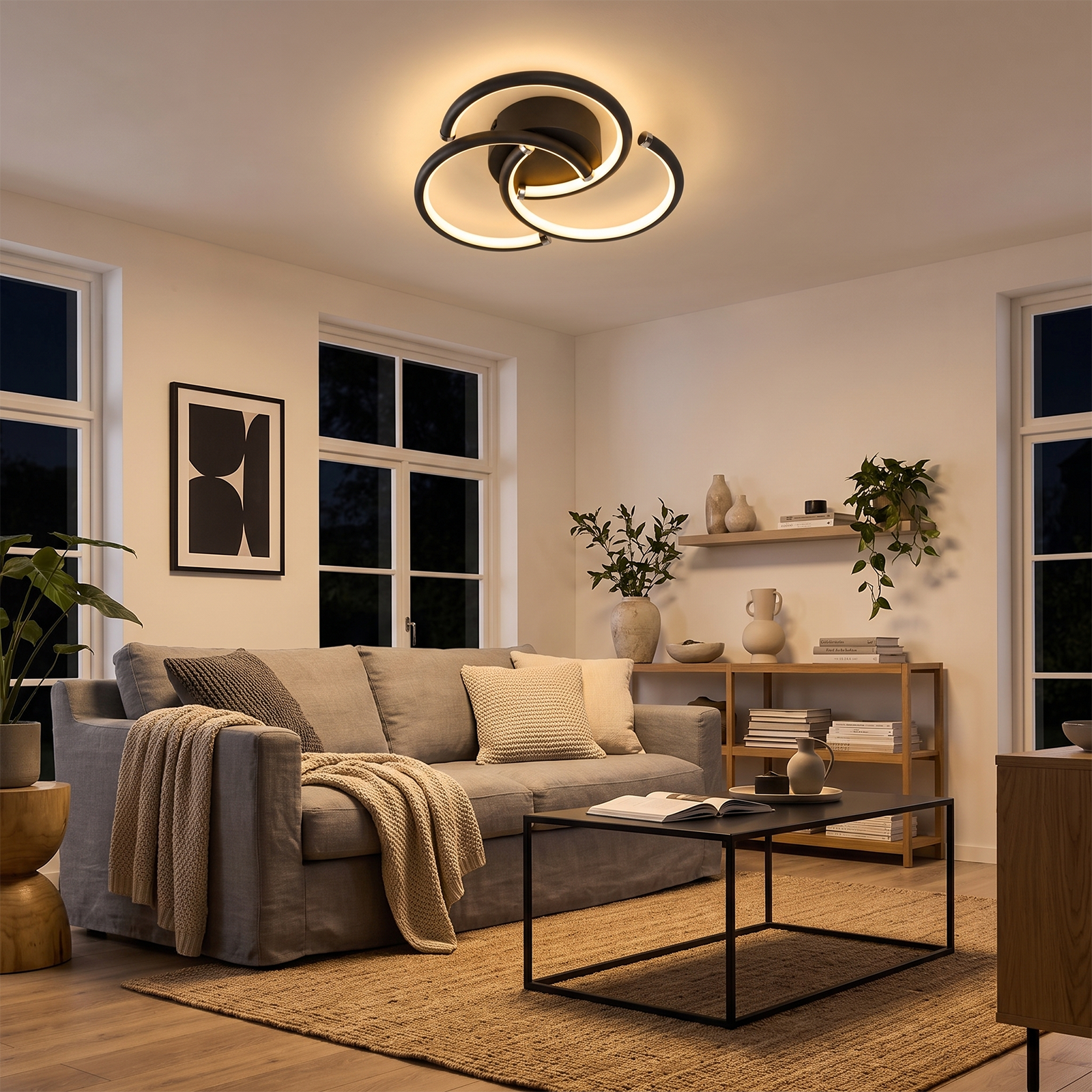 Una sala de estar moderna por noche con un sofá gris, mesa de centro negra y una lámpara de techo circular.