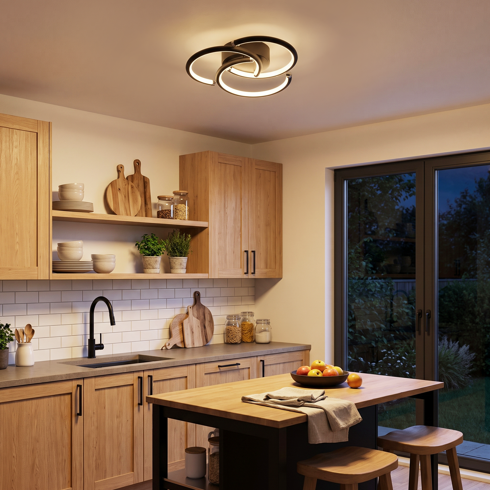 Cocina moderna con muebles de madera, una lámpara de techo, una isla con fruta y vista al jardín.