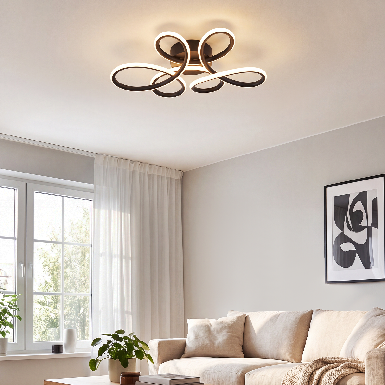 Lámpara de techo moderna con anillos curvos en una sala de estar luminosa con sofá y ventana.