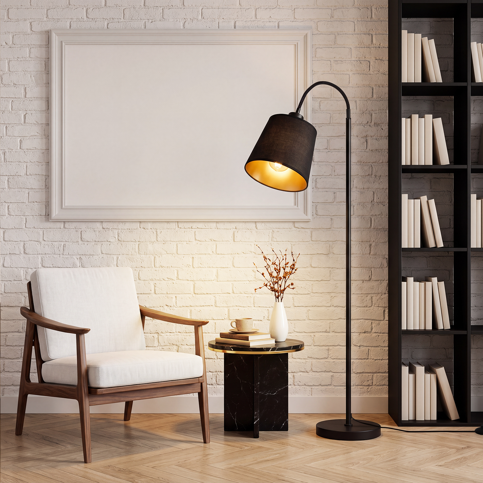 Rincón acogedor con sillón blanco, lámpara de pie, mesita con libros y florero, y estantería negra frente a pared de ladrillo.