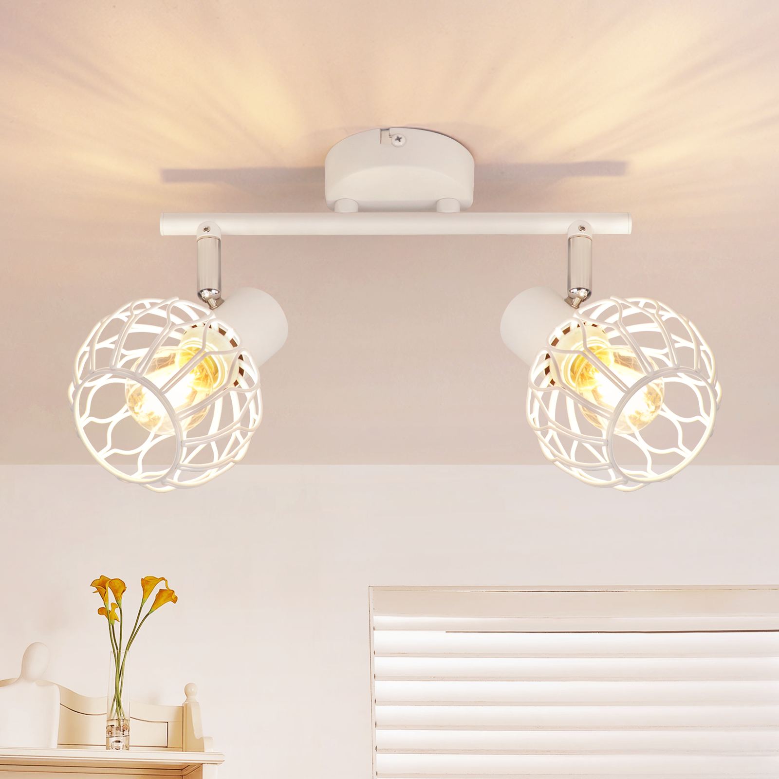 Lámpara de techo doble blanca con bombillas en jaula que iluminan una habitación.