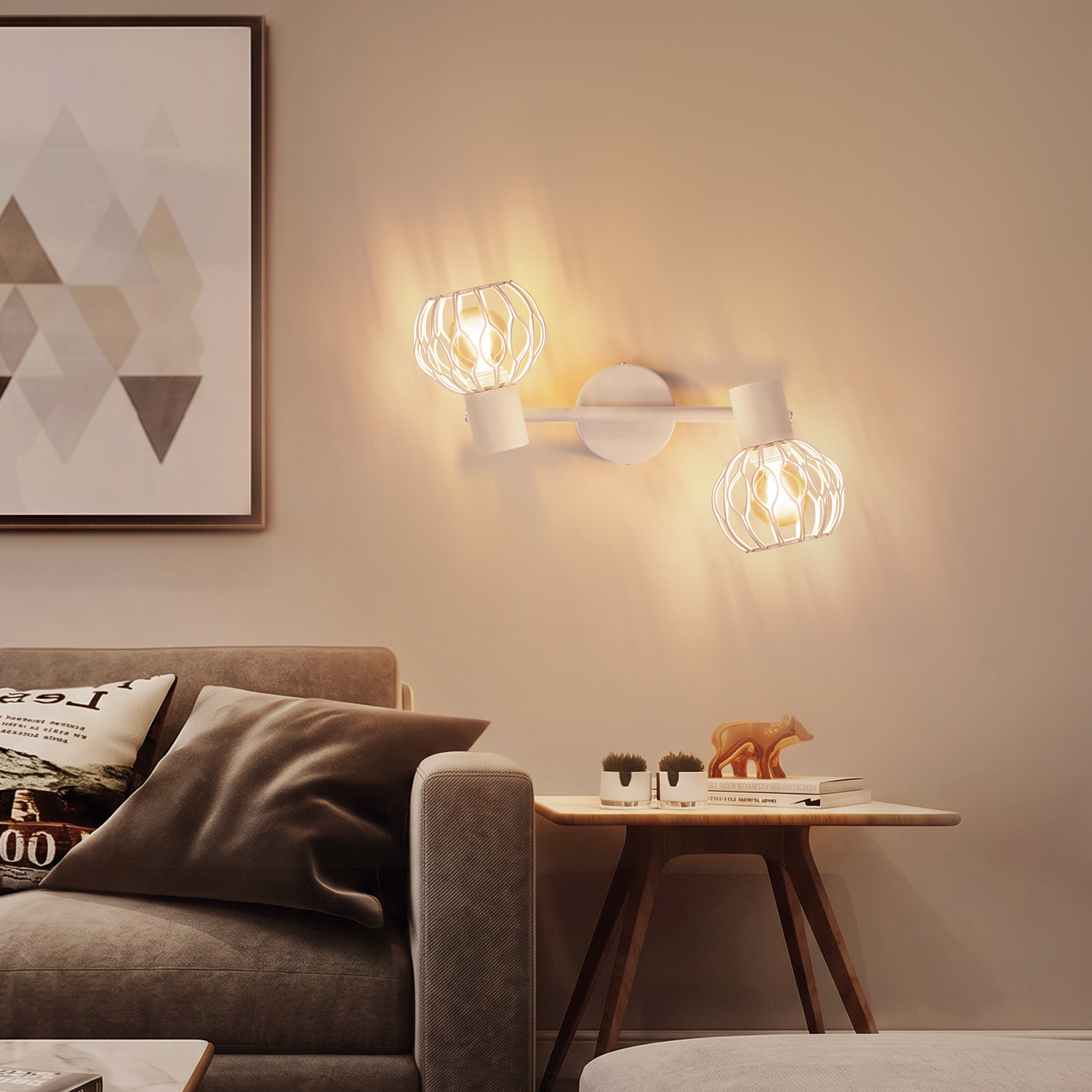 Sala de estar con aplique, sofá gris, mesa auxiliar con decoración y cuadro enmarcado.