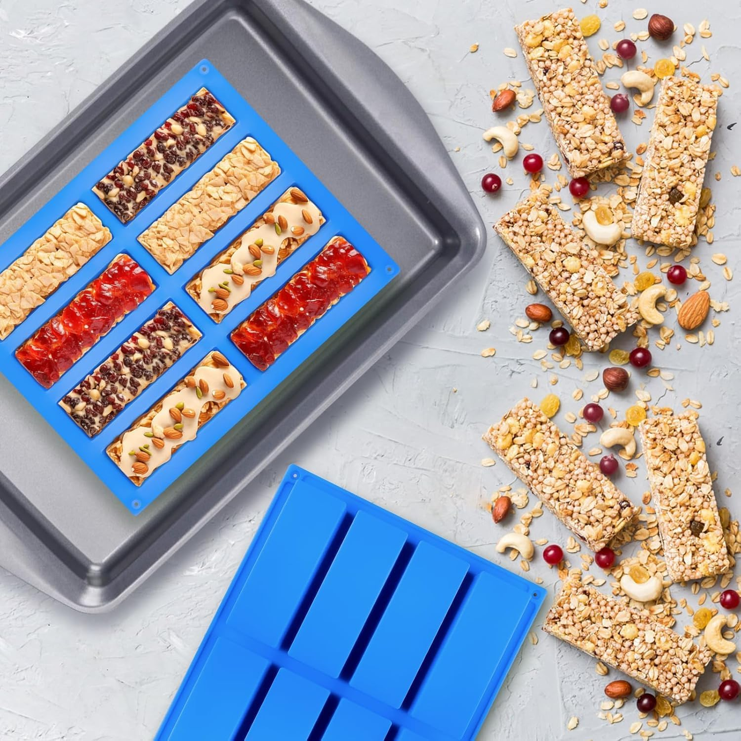 Müsliriegel in einer blauen Silikonform auf einem Backblech, umgeben von Haferflocken, Nüssen und Beeren.