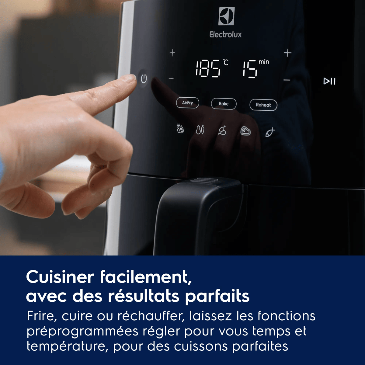 Ręka naciska przycisk zasilania na czarnej frytkownicy beztłuszczowej Electrolux z cyfrowym wyświetlaczem.