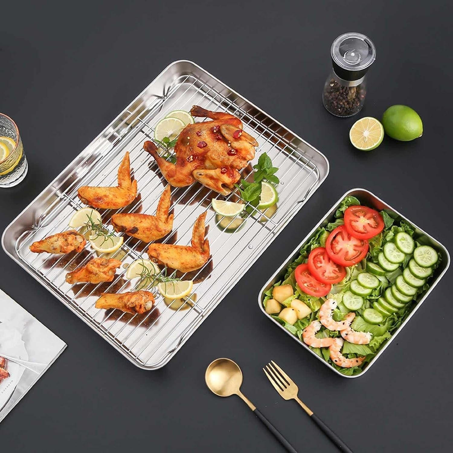 Brathähnchen und Flügel auf einem Kuchengitter neben einem frischen Salat auf dunklem Hintergrund.