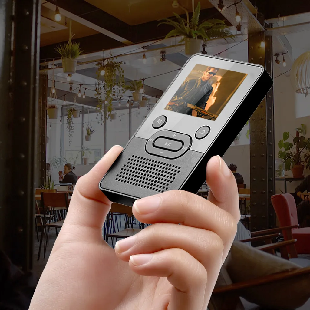 Eine Hand hält einen kleinen schwarzen Media-Player mit farbigem Display in einem Restaurant.