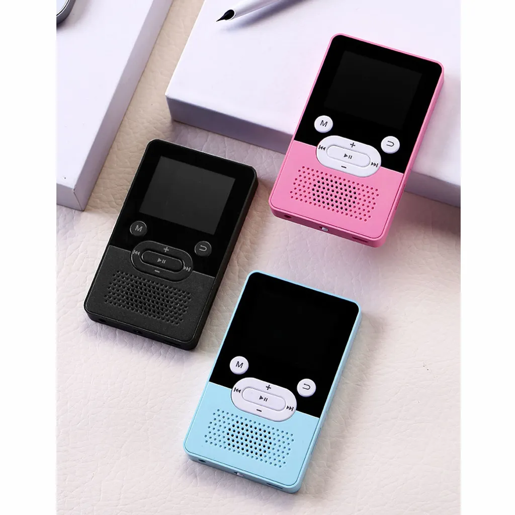 Drei kleine, tragbare Audioplayer in Schwarz, Pink und Blau auf einer weißen Oberfläche neben einer weißen Box.
