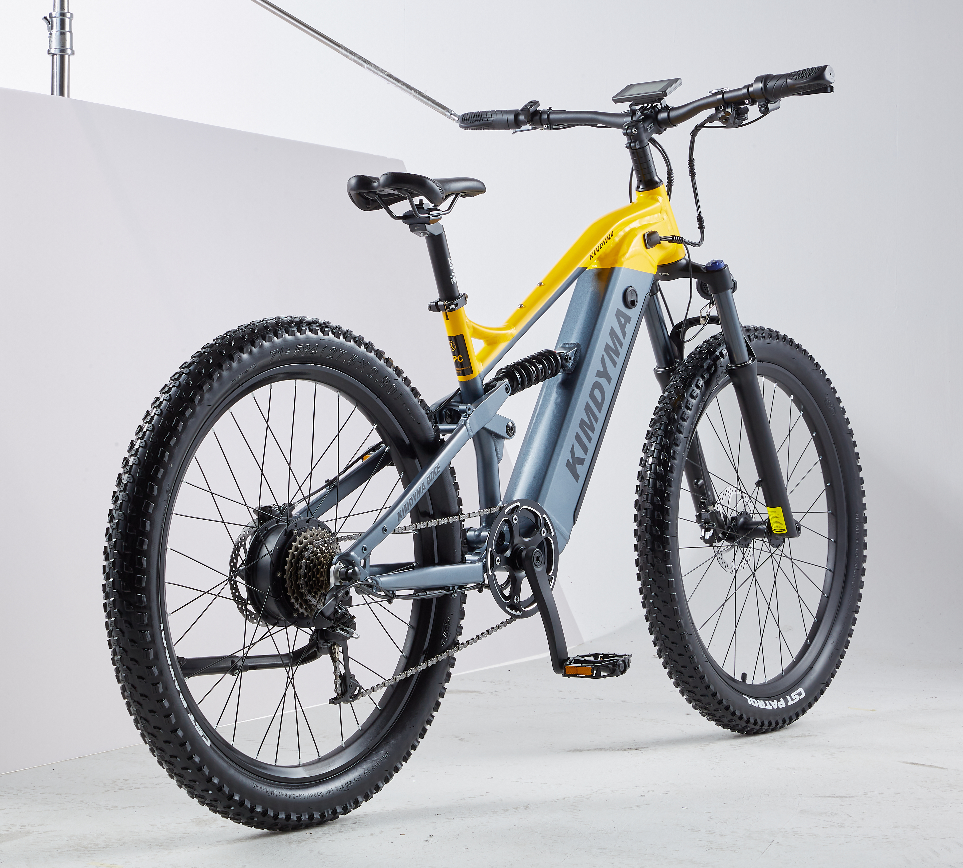 Una mountain bike elettrica KIMDYMA grigia e gialla su sfondo bianco in studio.