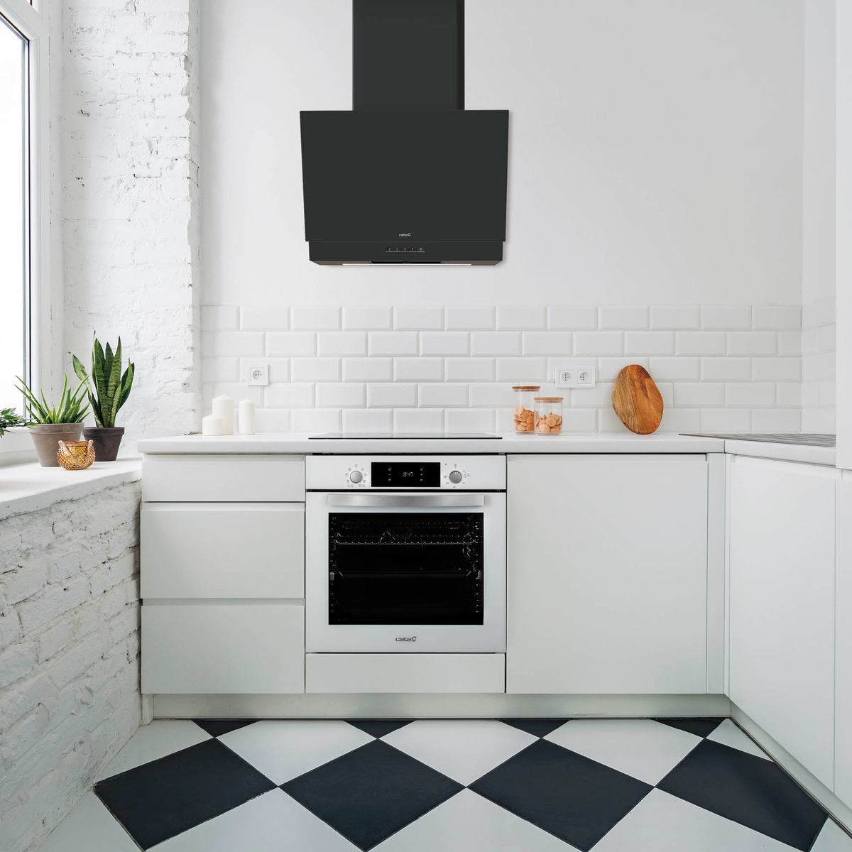 Cocina moderna con horno blanco, campana extractora negra, azulejos blancos y suelo a cuadros blanco y negro.