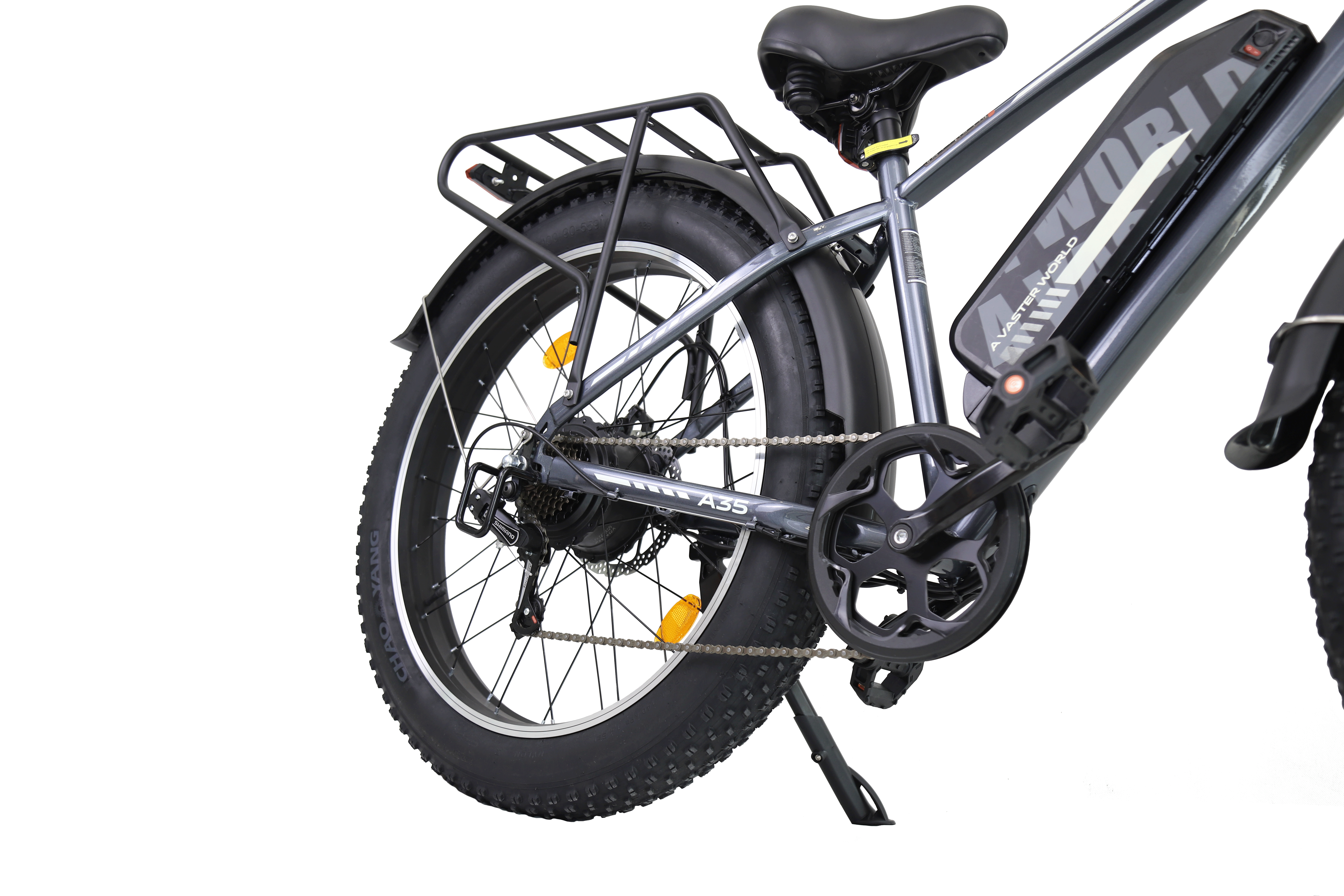 Vista laterale di una bicicletta elettrica grigia con pneumatici larghi, portapacchi, batteria e pedali.