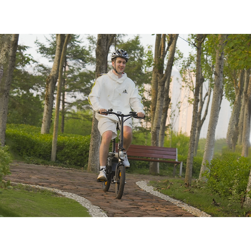 Un giovane con il casco guida una bici elettrica su un sentiero del parco.
