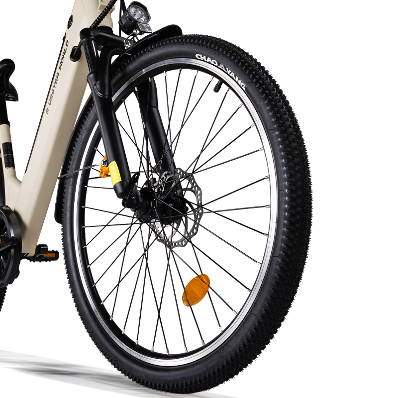 Primo piano della ruota anteriore di una e-bike beige con pneumatico tassellato e freno a disco su sfondo bianco.