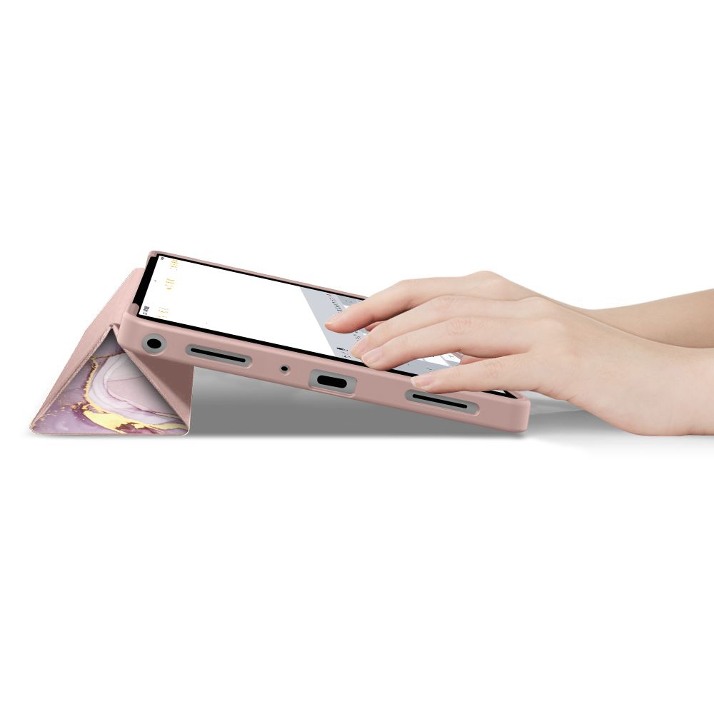 Una mano digita su un tablet in una custodia rosa marmorizzata su fondo bianco.